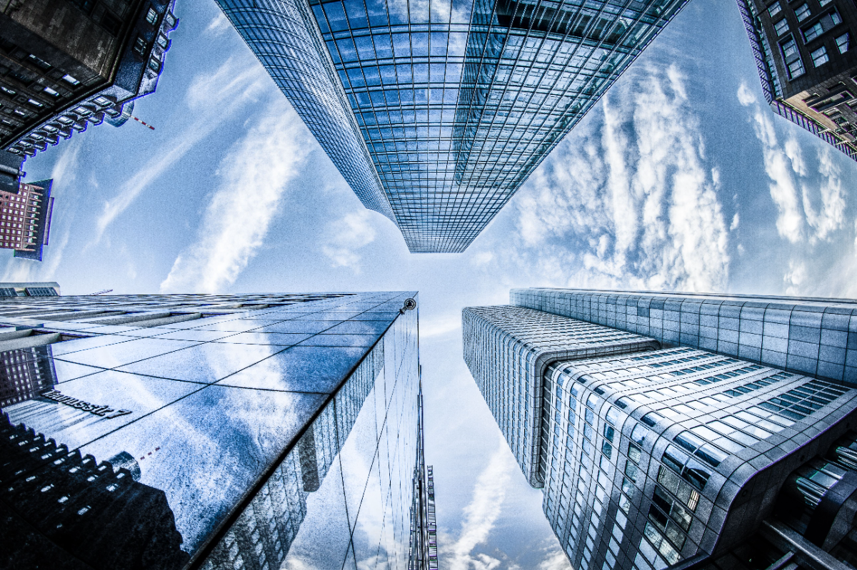 Low-angle Photo of Four High-rise Curtain Wall Buildings Under White Clouds and Blue Sky